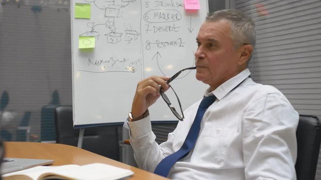 Senior manager elderly businessman feeling upset and tired of arguing colleagues office, work stress, burnout. Depressed grey-haired overworked employee office worker