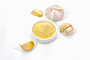 Ripe garlic isolated on white background. Fresh garlic cloves and powder in ceramic bowl. Spice cooking background