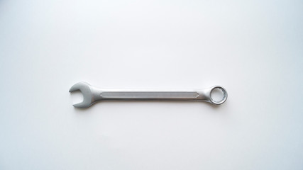One steel combination wrench lies on a white background.  Repair tool.