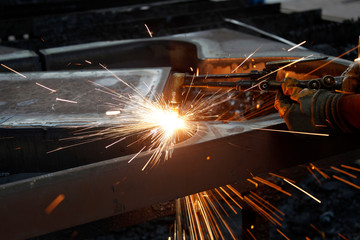 Industrial worker welding in steel factory