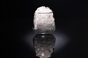 transparent glass with ice on black background