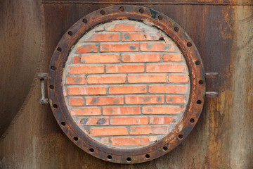 Closed metal tank with brick wall