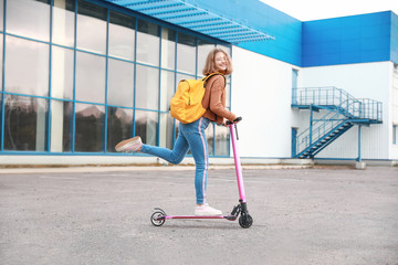Teenage girl riding kick scooter outdoors © Pixel-Shot