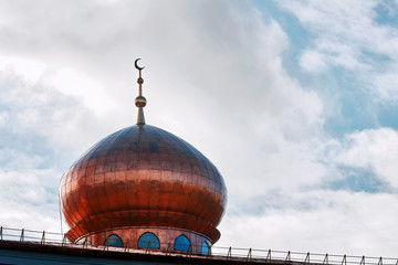 Mosque of Muslim religious association. Crescent on copper covered dome and minaret of mosque against blue sky. Symbol of Islam © Tricky Shark