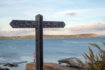 Signpost for the Cornish Coast Path on a peaceful autumn morning in Portscatho, Cornwall, UK