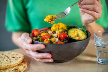 Close Up Of Woman Eating Healthy Vegan Meal In Bowl