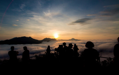 Fototapeta na wymiar Silhouette of tourists looking at mist and mountain with blue sky in nature landscape