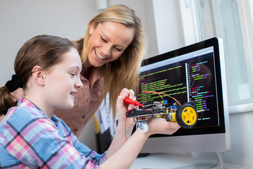 Female Teacher Helping Girl Building Robotic Car In Science Lesson © Daisy Daisy