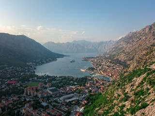 Fototapeta na wymiar Aerial view of the Bay of Kotor, Boka. Old city of Kotor, fortifications. Mountain of St.John and the fortress. Tourism and cruise ships. The bay is the largest fjord in the Mediterranean. Montenegro