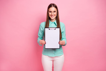 Portrait of positive charming cool girl hold clipboard demonstrate white paper needed for signing contracts with clients partners wear turquoise outfit isolated over pastel color background