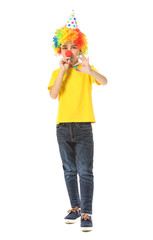 Little boy in funny disguise and with party whistle on white background. April fools' day celebration