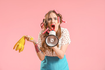 Funny housewife with megaphone on color background - obrazy, fototapety, plakaty