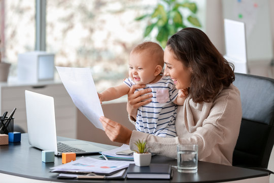 Working mother with her baby in office - Powered by Adobe