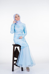 Attractive Muslim female model wearing pastel blue modern kurung with hijab, a urban lifestyle apparel for Muslim women isolated on white background. Beauty and hijab fashion concept. Full length