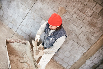 Real construction worker making a wall inside the new house.