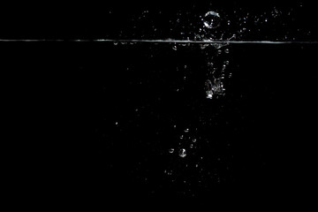 Obraz na płótnie Canvas something falls into the water and causes seething and air bubbles on a black background for installation