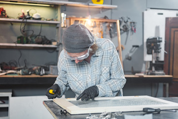 Carpenter working on the old wood in a retro vintage workshop.