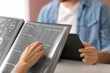 Young couple with menu sitting in restaurant