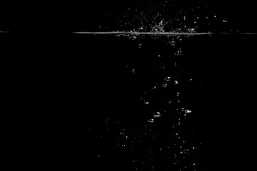 something falls into the water and causes seething and air bubbles on a black background for installation