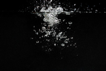 something falls into the water and causes seething and air bubbles on a black background for installation