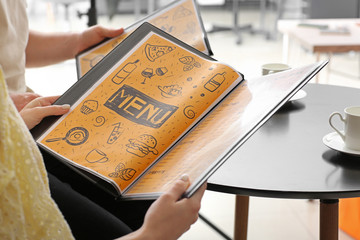 Young couple with menu sitting in restaurant