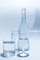 Transparent glass set with a bottle, isolated on a white background. Three glasses of water. 