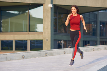 Young woman exercising / running in urban park.
