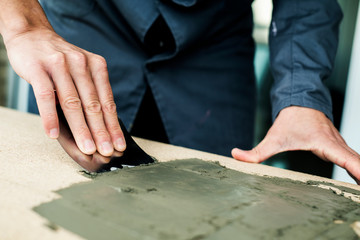 man spreading some concrete on a surface