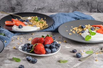 Ripe blueberries and strawberries with yogurt and granola