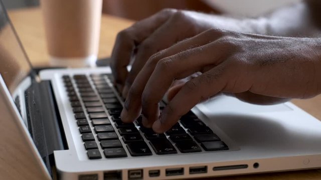 Close-up of a man's hands using the computer keyboard in the office.