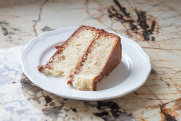 Slice of vanilla cake with chocolate frosting