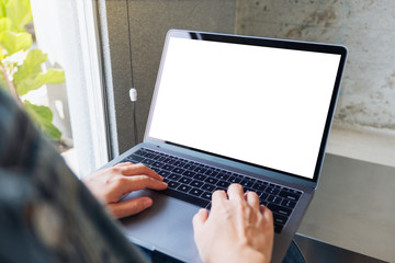 Mockup image of a woman using and typing on laptop computer with blank white desktop screen