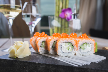 Traditional rolls with fish and rice on a white plate with sauce and wasabi. Japanese food.