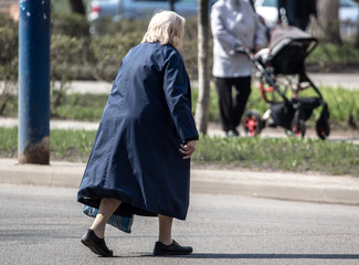 Grandmother in the city crosses the road