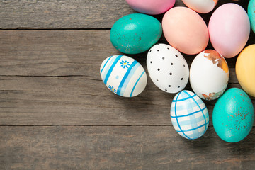 A lot of easter eggs on old wooden background, place for text, top view