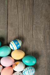 A lot of easter eggs on old wooden background, place for text, top view
