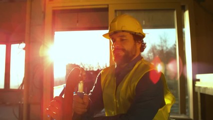 Slow motion, close up, lens flare experienced plumber tightens up a fitting into a hose with a spanner