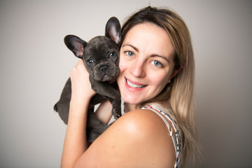 Beautiful woman with french bulldog over white