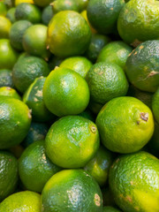 Green limes on the market as a background