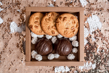 Chocolate marshmallows, white sugar candies and homemade cookies on a shiny background.Birthday present, valentine's day or christmas