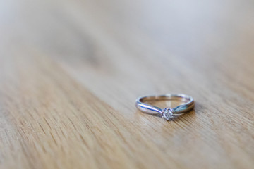 A silver engament ring on a wooden table