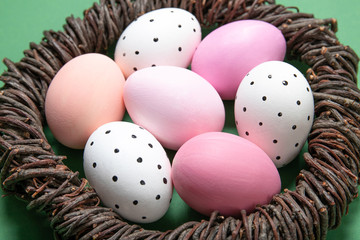 Easter eggs in a nest on a green background, place for text, top view,