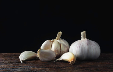 Fresh white garlic on wooden table with black background. Food and healthy concept.