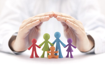 Family insurance concept with colorful family figurines covered by hands