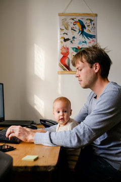 A father and his baby in front of a computer
