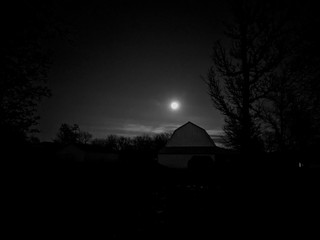 Moon lit barn black and white night sky