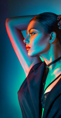 Sexy young beauty woman portrait, on colorful lights. Seductive brunette model girl in black sexy...