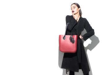 Fashion Model girl portrait, isolated on white background. Beauty look. Stylish brunette woman posing in fashionable clothes in studio. Spring fashion, black coat, trendy bag, Casual style
