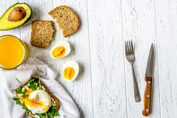 sandwich with poached eggs on wooden background top view mockup