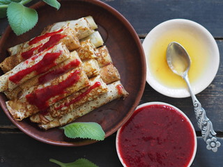 Pancakes with berries and sour cream for traditional winter Slavic holiday Maslenitsa or russian pancake week. Jam, honey on table